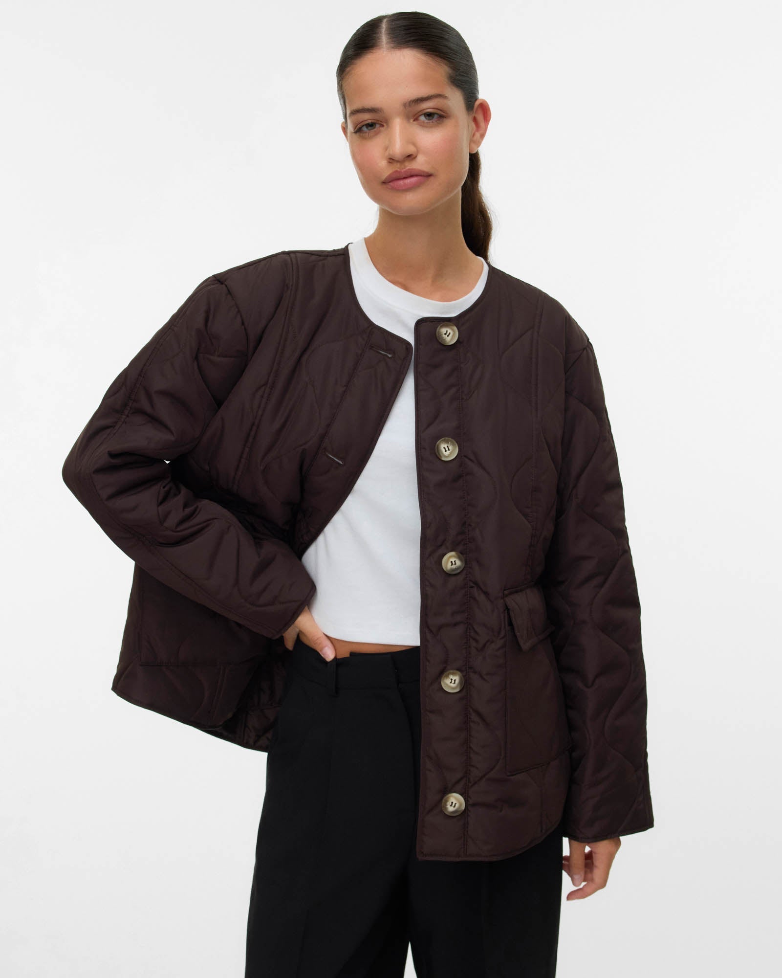 Woman wearing a brown jacket with button details on a white background